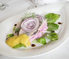 Mates mit roter Beete und Senf-Dill-Sauce auf weißem Teller